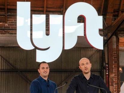 Lyft co-founders John Zimmer, left, and Logan Green speak before they ring a ceremonial opening bell in Los Angeles on March 29, 2019.