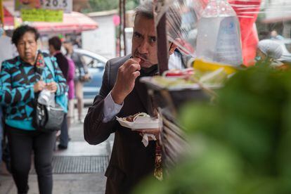 A man eats tacos at a Mexico City street stall in 2021.