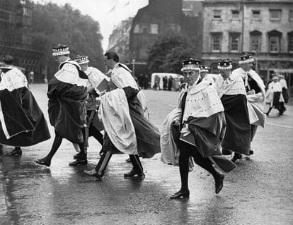 A group of peers hurrying from Westminster Abbey through the rain after the Coronation ceremony of Queen Elizabeth II.   