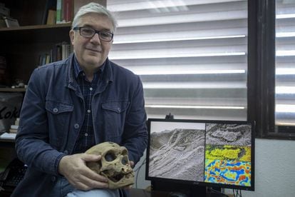Fernando Muñiz, one of the researchers who discovered the Neanderthal’s footprint, holds up a Neanderthal skull while displaying the evidence found in Gibraltar.