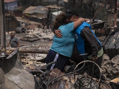 Two people hug each other among the remains of a house in Achupallas, in the Valparaíso region (Chile), last Sunday.