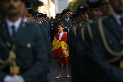 A child wrapped in a Spanish flag stands among Civil Guard officers.