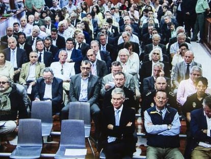 A photograph taken of a monitor screen outside the Málaga courtroom as the defendants prepared to hear the sentence. Former Marbella Mayor Julián Muñoz is second from the right in the front row, next to Juan Antonio Roca (head bowed),