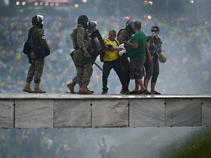 Members of the Brazilian security forces detain pro-Bolsonaro protestors at the Planalto Palace in Brasília, on Sunday, January 8, 2023.