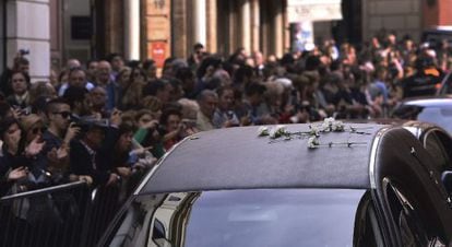 Hundreds of people line the streets of Seville as the funeral car of the Duchess of Alba passes.