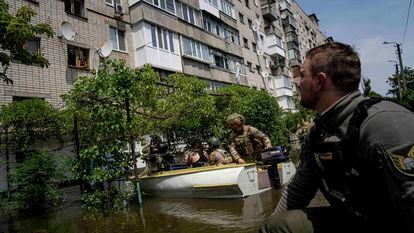 Ukrainian soldiers rescue people trapped by floodwaters in Kherson on Thursday.