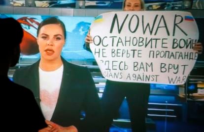 Marina Ovsyannikova holds up a sign reading 'No War. Stop the war. Don't believe the propaganda. You are being lied to here' during a broadcast of Russia's Channel One evening news on 15 March 2022. 