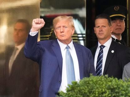 Former President Donald Trump, left, gestures as he leaves Trump Tower in New York, on April 13, 2023.