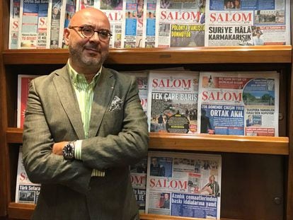 Ivo Molina, the director of the weekly newspaper Salom, in front of a stand displaying copies of his publication.