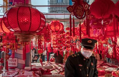 A Chinese soldier patrols a market for Chinese New Year decorations.