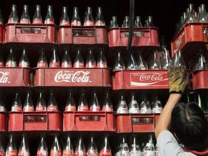 A worker stacks crates of empty Coca-Cola bottles in México.