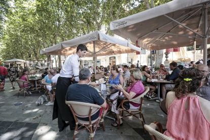 Tourists enjoy drinks and snacks at a terrace bar in Palma de Mallorca.
