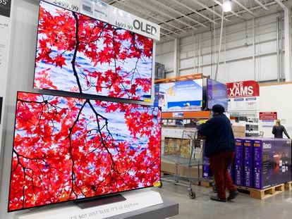 A customer walks past televisions at a Costco in Washington, DC, USA, 22 February 2024.