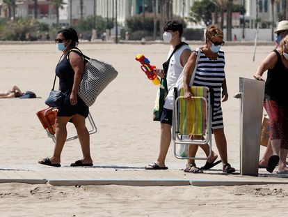 A group of people wear face masks in Malvarrosa beach in Valencia.