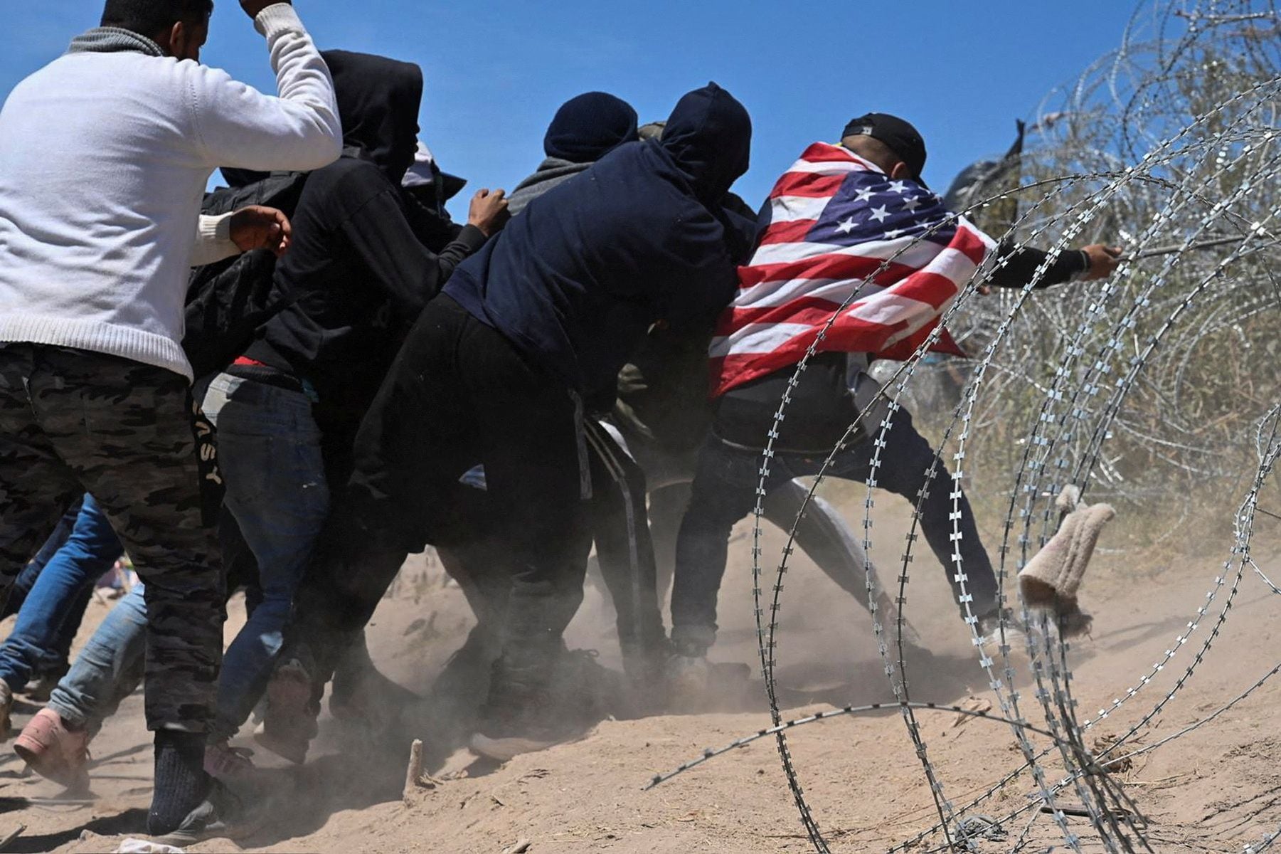 A group of migrants attempts to break through concertina wire in El Paso, Texas, last week.