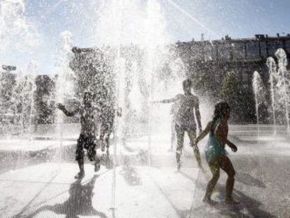 Youngsters play in fountains in the Yamaguchi park in Pamplona.