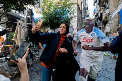 A tourist takes a selfie with a cutout of Napoli’s star player Victor Osimhen. 