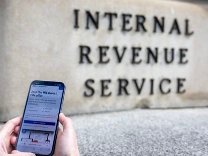 A person uses IRS Free File software in front of the Internal Revenue Service building in Washington (DC).