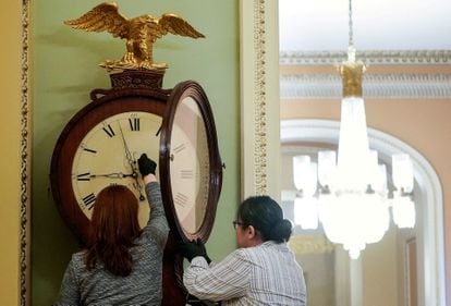 Employees with the Architect of the Capitol wind the Ohio Clock in the U.S. Capitol in Washington.