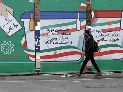 A man walks past an election poster in Tehran on Wednesday, February 27, 2024.