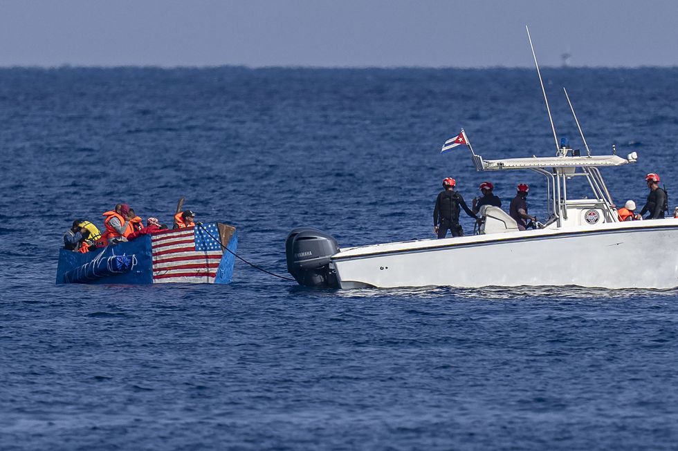 Ein mit der Flagge der Vereinigten Staaten bemaltes Floß wird von der kubanischen Küstenwache abgefangen. | Bildquelle: El País © Ramon Espinosa/AP | Bilder sind in der Regel urheberrechtlich geschützt