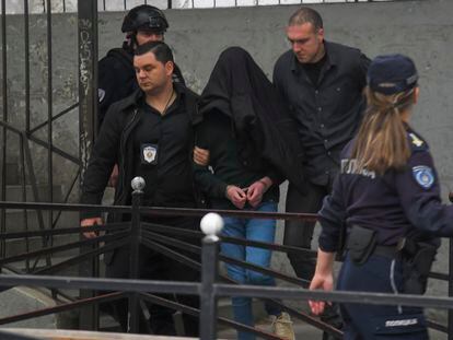 A suspect is escorted by police outside the Vladislav Ribnikar school in Belgrade, Serbia, Wednesday, May 3, 2023.