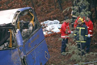 Firefighters stand next to bodies covered by blankets and the bus that fell into a ravine in Sert&atilde; district of Castelo Branco on Sunday.