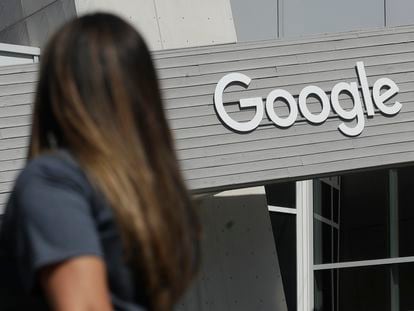 In this Sept. 24, 2019, file photo a woman walks below a Google sign on the campus in Mountain View, Calif.  Alphabet reports earnings on Tuesday, April 25, 2023
