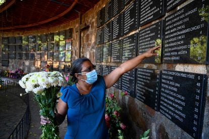 María de La Paz Chicas places flowers for children killed during El Mozote massacre, in November 2021.