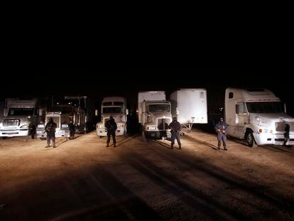 Police officers stand in front of stolen cargo trucks, on the outskirts of Tijuana, in the Mexican state of Baja California.