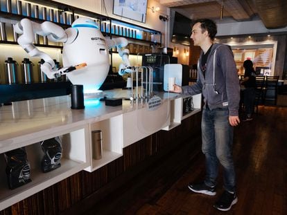 Adam, a robot, prepares coffee for a customer at the Botbar coffee shop in New York on May 31, 2023.