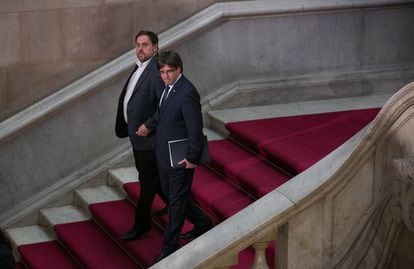 Deputy Catalan Premier Oriol Junqueras (left) and Catalan Premier Carles Puigdemont leave a session of the regional parliament.