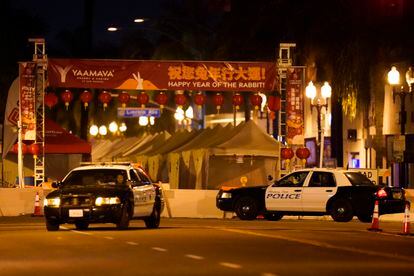 Two police vehicles are seen near a building where a shooting occurred in Monterey Park, Calif., Sunday, Jan. 22, 2023.