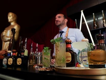 A bartender stands behind a counter with prepared drinks placed on it during a preview of the food, beverages and decor of this year's Governors Ball, the Academy's official post-Oscars celebration following the 94th Oscars ceremony in Los Angeles, California, U.S. March 24, 2022.