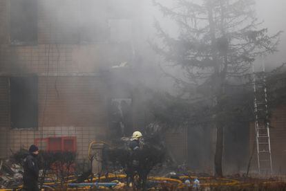 Emergency personnel work at the site of a helicopter crash, amid Russia's attack on Ukraine, in the town of Brovary, outside Kyiv.