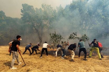 Locals in Villarejo try to put out a fire hotspot.