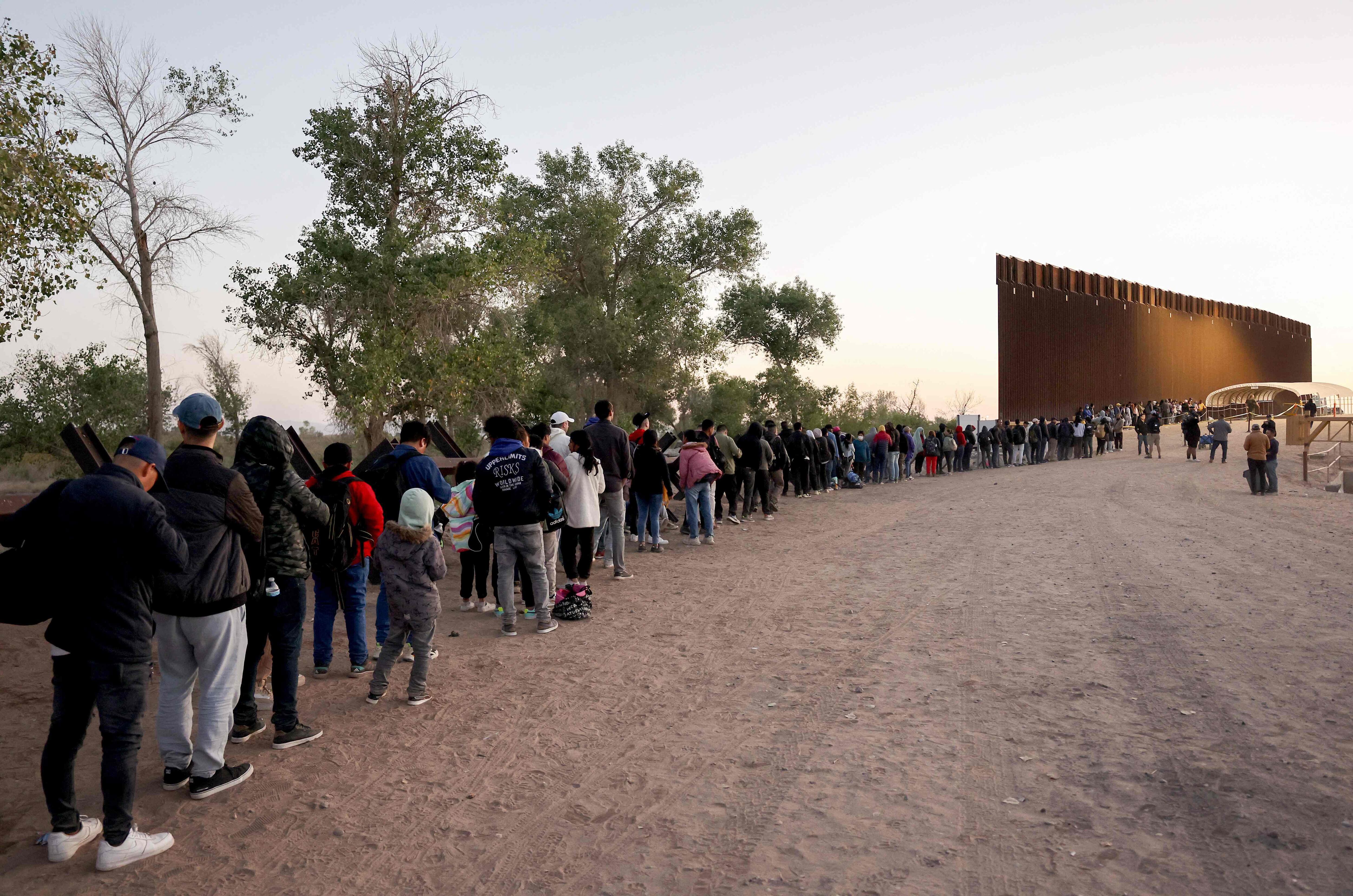 Migrants wait in line in Yuma, Arizona, on Wednesday, May 10, 2023.
