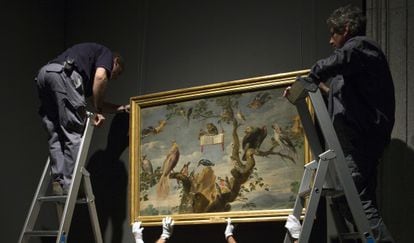 Workers handle a painting at the Prado Museum.