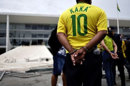 A Bolsonaro supporter stands in handcuffs outside the Planalto Palace, on January 8, 2023.