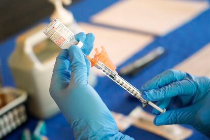 A nurse prepares a syringe of a COVID-19 vaccine at an inoculation station in Jackson, Miss., July 19, 2022.