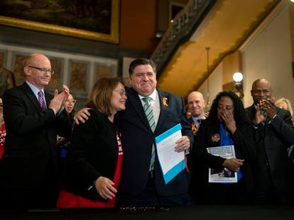 Illinois Gov. J.B. Pritzker hugs gun control advocate Maria Pike after he signed comprehensive legislation to ban military-style firearms on Jan. 10, 2023, at the Illinois State Capitol.