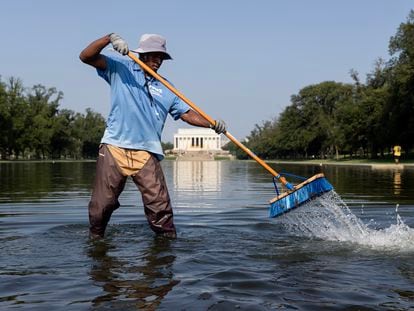 A worker clears algae and debris from the Lincoln Memorial Reflecting Pool on the National Mall, during a heat advisory in Washington, DC, USA, 28 July 2023.
