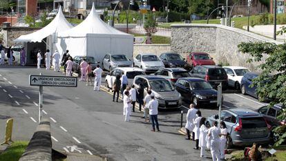 Healthcare workers at Basurto hospital wait in line on Saturday to undergo coronavirus tests.