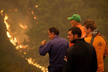 Residents watch on as a fires burns near the Os Ancares natural reserve.