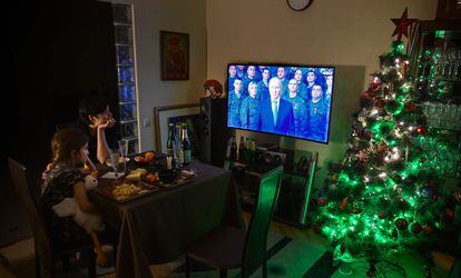 A family watches Vladimir Putin's New Year speech on television on December 31 in Moscow.