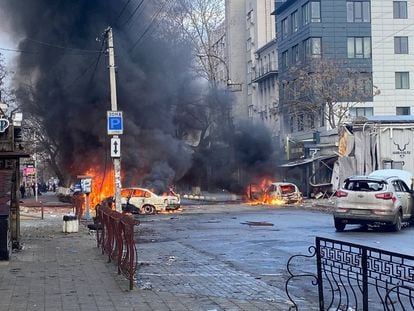 Cars burn on a street after a Russian military strike in Kherson, Ukraine, December 24, 2022.