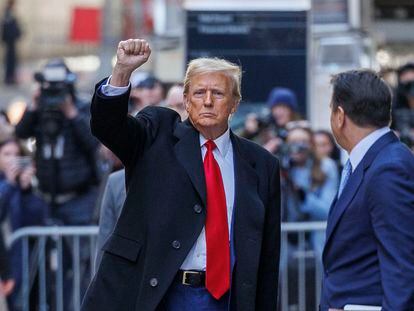 Former U.S. president Donald Trump raises his fist after leaving a New York appeals court, which lowered his bond payment in a civil fraud case on March 25.