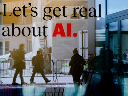 People reflected in a window of a hotel at the Davos Promenade with a slogan about AI alongside the World Economic Forum in Davos, Switzerland, Monday, Jan. 15, 2024.