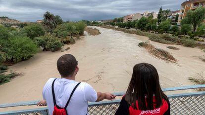 Two people watch the Segura River flood through Archena (Murcia) after it overflowed on Thursday.