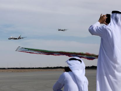 An Airbus A380 (Up-L) and Boeing 777 (Up-R) aircrafts owned by Emirates Airlines with Al Fursan aerobatics demonstration team of the United Arab Emirates Air Force perform during the Dubai Airshow in Dubai, United Arab Emirates, November 13 2023.